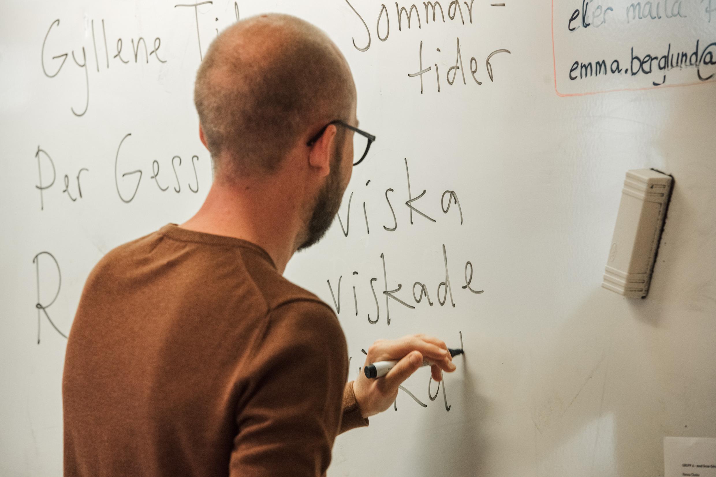 A man writing on a whiteboard.