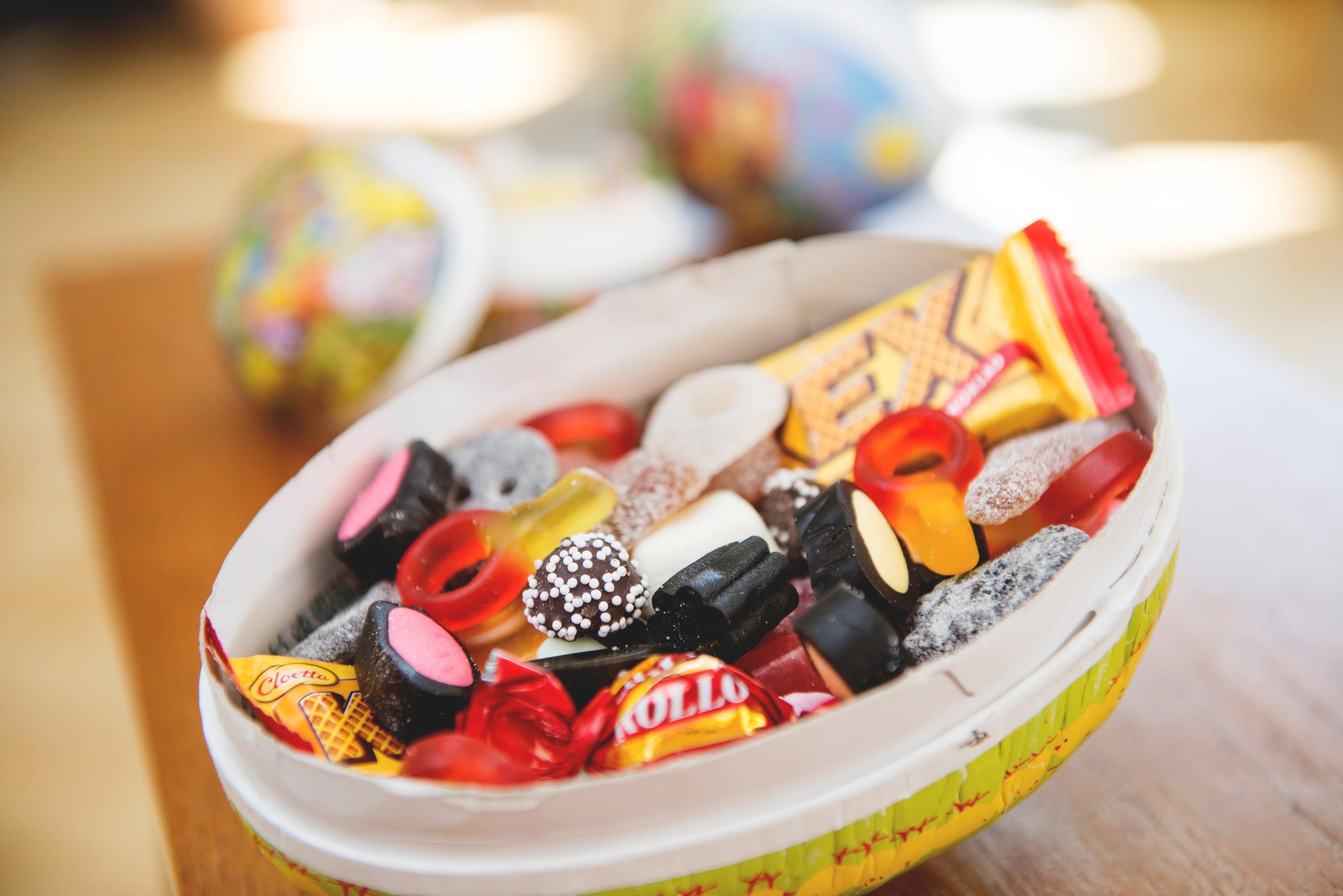 Easter candy eggs وعاء ورقي على شكل بيضة مملوء بالحلوى.